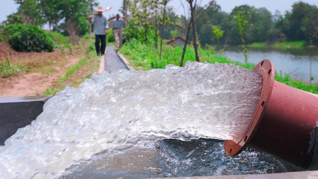 High-volume irrigation discharge from a large-diameter pipe, typical of 10 inch submersible pump output.