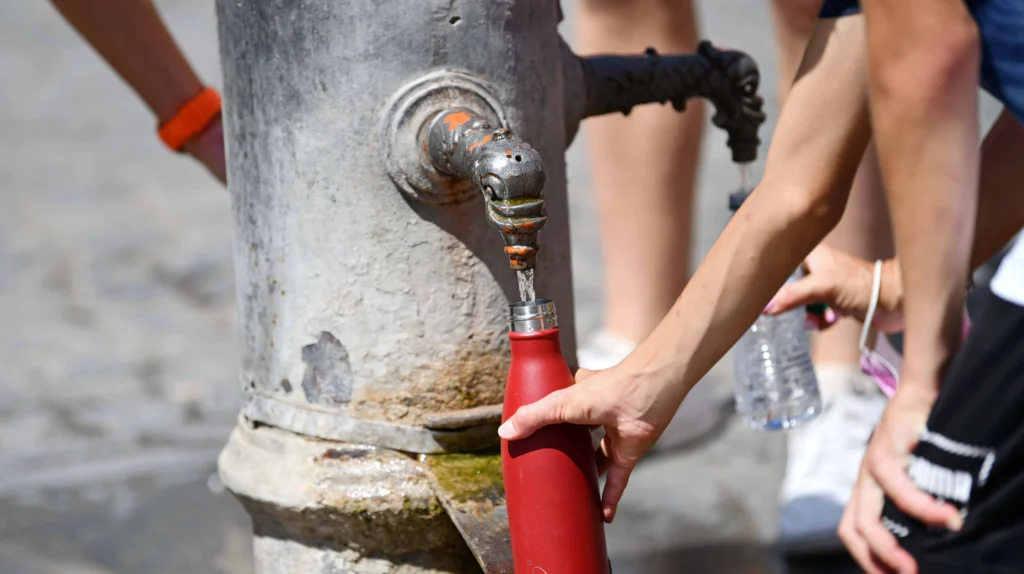 Filling a red bottle at a 4sp3 public drinking tap.