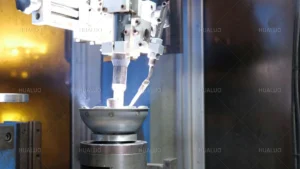 Automated machine performs luminous welding on a metal submersible pump part in a factory.