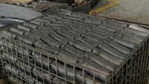 Wire basket filled with stacked motor rotors for large-scale production of submersible pumps and fountain pumps.