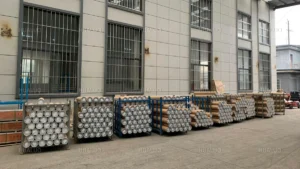 Cylindrical packaging for submersible pumps stored on racks in a water pump factory.